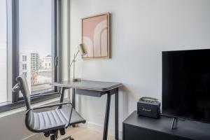 una scrivania con una sedia in una stanza con una TV di Blueground SoMa pool nr Civic Center SFO-1373 a San Francisco Altre 46 foto