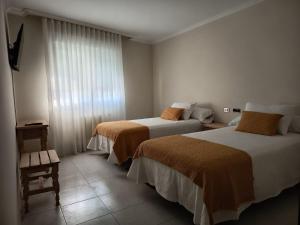 a hotel room with two beds and a window at Hotel Alejandrina Poio in Poio