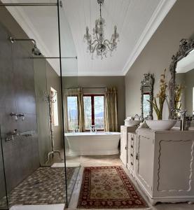 a bathroom with a tub and a shower and a chandelier at Belle Vallee Guestroom 1 in Wellington