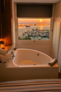 a large bath tub in a room with a window at B&B 106 Maison de Charme in Mola di Bari