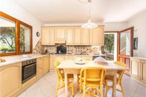 a kitchen with a wooden table and chairs at Casa Ortensia in Baja Sardinia