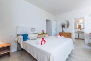 a bedroom with a white bed with red bows on it at Casa Ortensia in Baja Sardinia