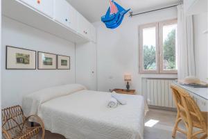 a white bedroom with two beds and a window at Casa Ortensia in Baja Sardinia