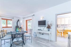 a dining room and living room with a table and a television at Casa Ortensia in Baja Sardinia