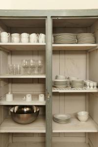 a cabinet filled with plates and bowls and dishes at Light Flooded Apartment With Sauna in Walow