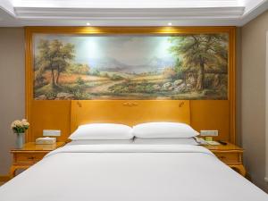 Rúm í herbergi á Vienna International Hotel Changsha BBK Meixi Xintiandi Branch