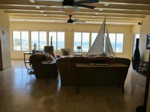 a living room with a couch with a sail boat on it at Villa Luminara- Lux Pool, Garden, Retreat & Beach in Oyster Pond