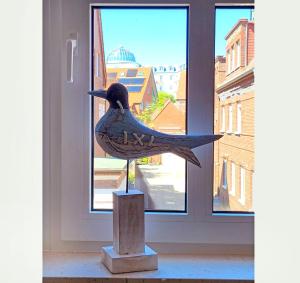 una estatua de un pájaro parado frente a una ventana en Inselresidenz Strandburg Juist Ferienwohnung 50955, en Juist