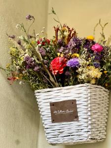 a basket full of flowers sitting on a wall at DeTillierStudiò2 in Aosta
