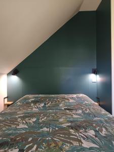 una camera da letto con un letto e una parete verde di Appartement Studio Prieuré a Quimper