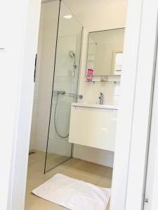 a bathroom with a shower and a sink and a mirror at Apartman Sanja in Vlašići +17 photos