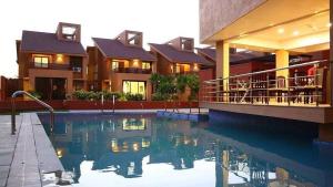 拉杰果德Palette The Royal Castle Resort Rajkot的一栋前面有游泳池的房子
