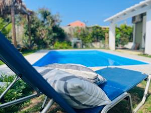 a blue chair next to a swimming pool at Olive and Blue Retreat in Halikounas