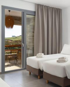 a bedroom with two beds and a sliding glass door at Spanos Apartments in Agios Petros +35 photos