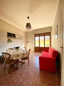 a living room with a table and a red couch at Comodo e Pratico nel Cuore pulsante di Pisa in Pisa +31 photos