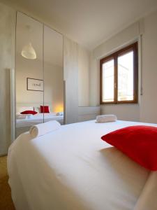 a bedroom with a large white bed with red pillows at Comodo e Pratico nel Cuore pulsante di Pisa in Pisa