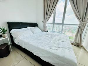 un grand lit dans une chambre avec une grande fenêtre dans l'établissement Modern Family-Fun Suites - Infinity Pool, Ps5, Pool table, Indoor-Cinema with Balcony - M1, à Bukit Mertajam