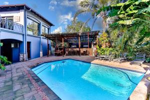 a swimming pool in front of a house at RR001 Robbins Road - A home away from home in Ballito