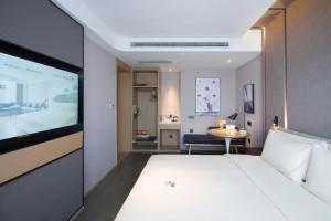 a hotel room with a bed and a television at Atour Hotel Taiyuan Jinci Road Polytechnic University in Taiyuan
