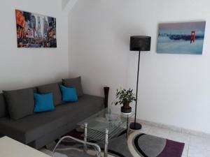 a living room with a couch and a glass table at Du côté de chez Rosélia in Bédarieux