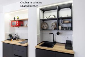 a kitchen with black cabinets and a sink at Casa Zio Lele in Cefalù +18 photos