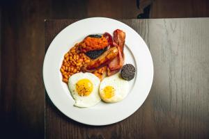 a plate of breakfast food with eggs bacon and beans at The Grand Hotel Birmingham in Birmingham