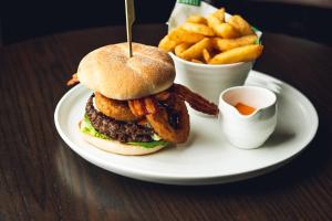 a plate with a hamburger and french fries on a table at The Grand Hotel Birmingham in Birmingham