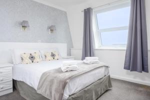a bedroom with a bed with two towels on it at Barrowfield Hotel in Newquay