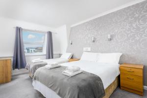 a hotel room with two beds and a window at Barrowfield Hotel in Newquay
