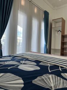 a bedroom with a bed with a blue and white blanket at RUMAH 25 SYARIAH in Bukittinggi