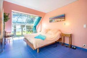 a bedroom with a bed and a window at Coin de paradis face à l'océan in Loctudy