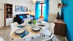 una sala da pranzo con un tavolo bianco e sedie bianche di A casa di Nina & Turi con giardino e veranda a Dongo