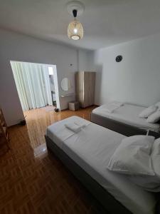 a bedroom with two beds and a chandelier at Nardi Guesthouse in Ksamil