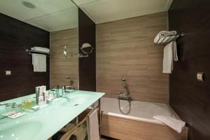 a bathroom with a sink and a bath tub at Hotel Diagonal Plaza in Zaragoza