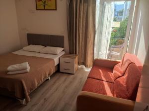a bedroom with a bed and a window and a couch at Garden Prizma Apart in Kemer +14 photos