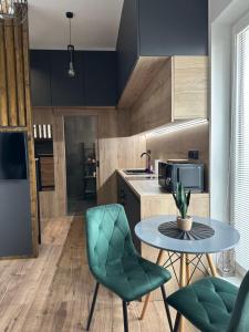 a kitchen with a table and two green chairs at Apartment lilly in Poprad