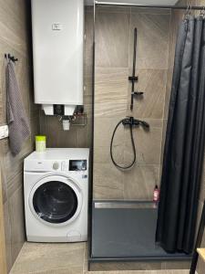 a washing machine in a bathroom with a shower at Apartment lilly in Poprad
