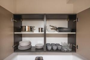 ein Schrank mit Tellern und Geschirr in einer Küche in der Unterkunft Appartamento Sagittario in Misano Adriatico