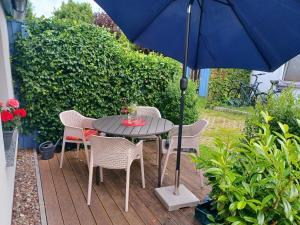 a table and chairs with an umbrella on a patio at FeWo Seeadler - Heuser Prerow in Prerow