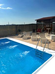a swimming pool with chairs and a table at Villa La Espiga in Valladolid