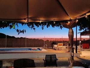 a view of a pool with chairs and an umbrella at Villa La Espiga in Valladolid