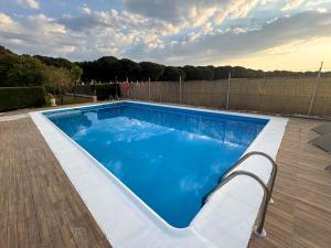 a swimming pool with blue water in a yard at Villa La Espiga in Valladolid