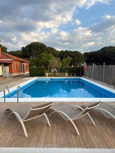a pair of chairs sitting next to a swimming pool at Villa La Espiga in Valladolid