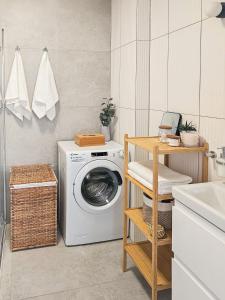 a laundry room with a washing machine and a sink at Kairos Apartments -Aramis- darmowy parking, klimatyzacja in Olsztynek