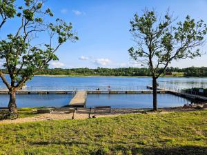 a dock on a lake with a bench and trees at Kairos Apartments -Aramis- darmowy parking, klimatyzacja in Olsztynek