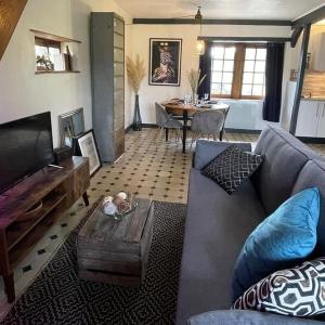 a living room with a couch and a table at La Chaumière aux Animaux in Touffreville-la-Corbeline