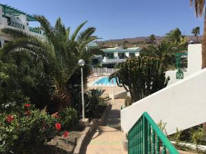a resort with a swimming pool and palm trees at Aguycan - Bungalow with ocean views in San Bartolomé de Tirajana