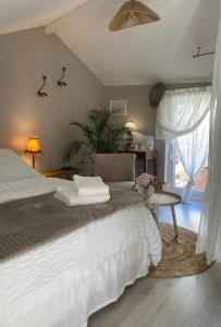 Un dormitorio con una cama y una mesa y una ventana. en L'Inattendue - Chambre Cosy à 150m de la plage, en La Bernerie-en-Retz
