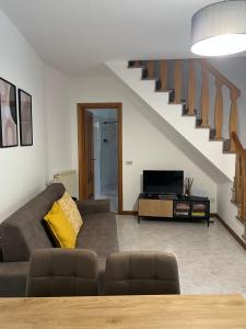 a living room with a couch and a staircase at Ardesia apartment in Crocetta