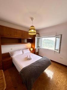 Un dormitorio con una cama grande y una ventana. en La Ponderosa, en Castañeras